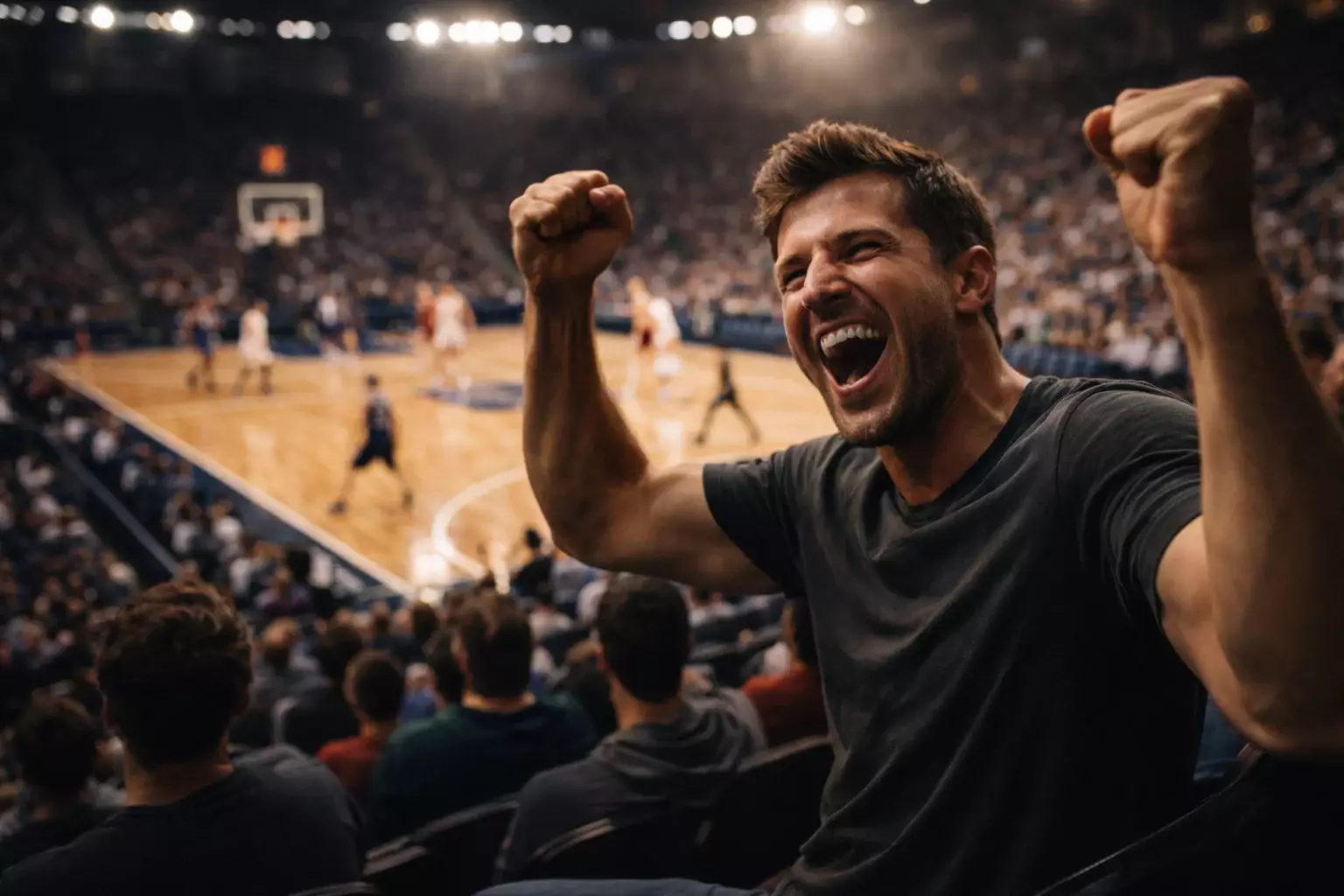 Aficionado de baloncesto celebrando con los puños en alto mientras ve un partido en un pabellón deportivo