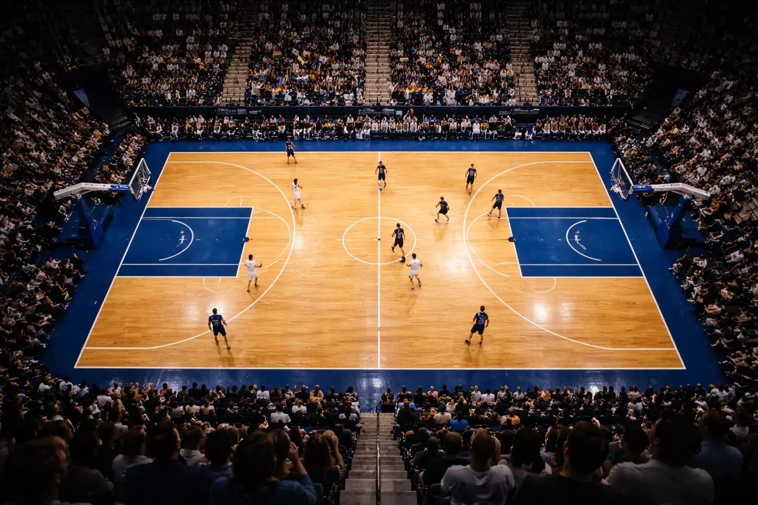 Cancha de baloncesto NBA vista desde arriba con jugadores en acción durante un partido nocturno
